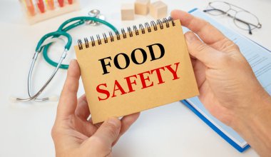 Bir doktorun ve steteskopun elinde Gıda Güvenliği mesajı olan bir not. Tıbbi konsept..