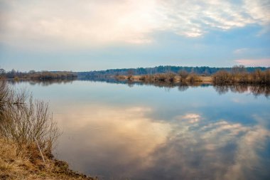 Sabahın doğuşu ve gökyüzünün yansıması nehrin su yüzeyinde. Nehrin üzerinde mavi gökyüzü