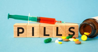 Tahta bloklara yazılmış PILLS kelimesi. Tıbbi konsept