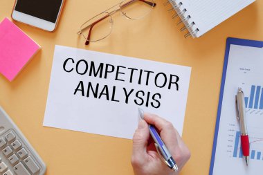 Kağıt üzerinde COMPETITOR ANALYSIS yazan kağıt kırtasiye arasında ofis masasında.