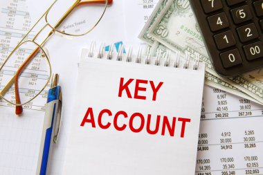Ofis masasında, kırtasiyenin arasında KEY ACCOUNT metni bulunan defter.