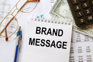 Brand MESSAGE bir not defterine, ofis aksesuarlarıyla birlikte bir ofis masasına yazılmıştır..