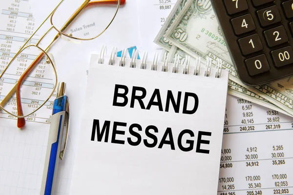 Brand MESSAGE bir not defterine, ofis aksesuarlarıyla birlikte bir ofis masasına yazılmıştır..