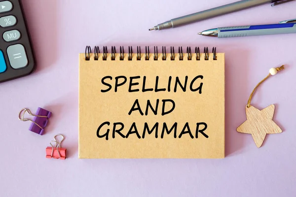 Spelling and Grammar is written on a notepad on an office desk with office accessories.