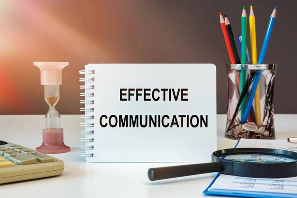 Effective Communication is written on a notepad on an office desk with office accessories.