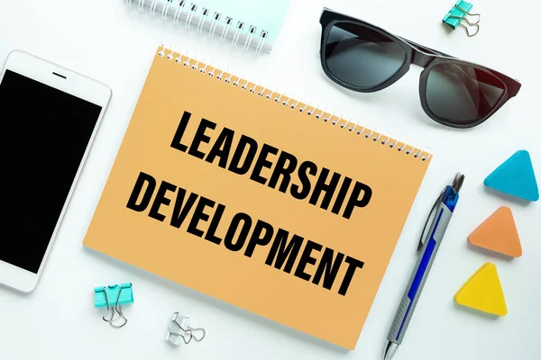 Leadership Development is written on a notepad on an office desk with office accessories.