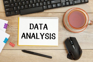 Ofis masası ve yazılı defter - DATA ANALYSIS, klavye ve bir fincan çay