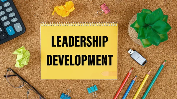 Leadership Development is written on a notepad on an office desk with office accessories.