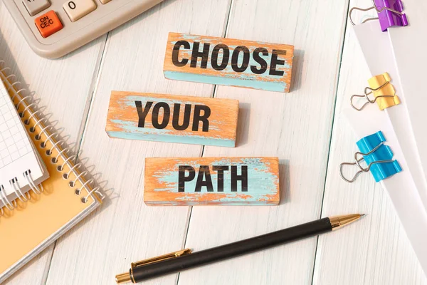 CHOOSE YOUR PATH - words written on wooden blocks near office supplies