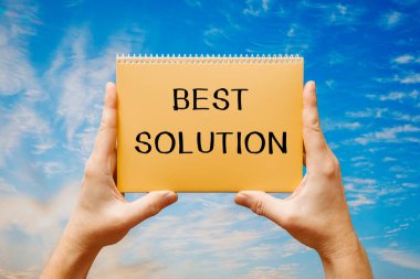 Bir adam mavi gökyüzünün arka planında en iyi mesajı içeren bir kart tutuyor..