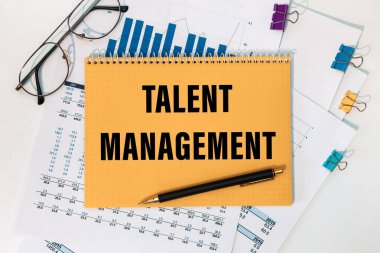 Beyaz arkaplanda yazı, belge, kalem ve gözlük bulunan bir not defteri