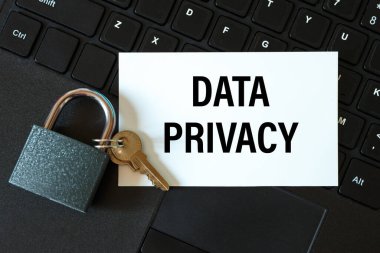 Veri gizliliği - bir kartta bir yazı ve bir bilgisayar klavyesinin arka planında bir kilit