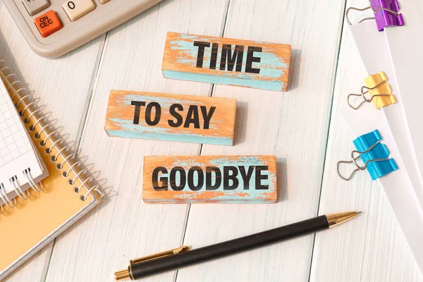TIME TO SAY GOODBYE - words written on wooden blocks near office supplies