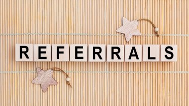 Ahşap arka planda kısaltması REFERRALS olan tahta küpler