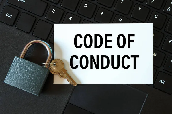 CODE OF CONDUCT - an inscription on a card and a lock on the background of a computer keyboard