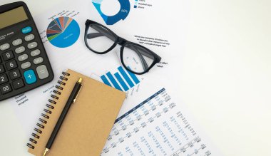 Belgeler ve hesap makinesiyle çalışan iş muhasebecisi beyaz ofis masasında, üst görünüm