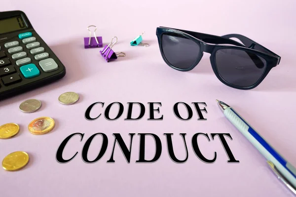 Text writing CODE OF CONDUCT. Calculator, money and glasses on the table