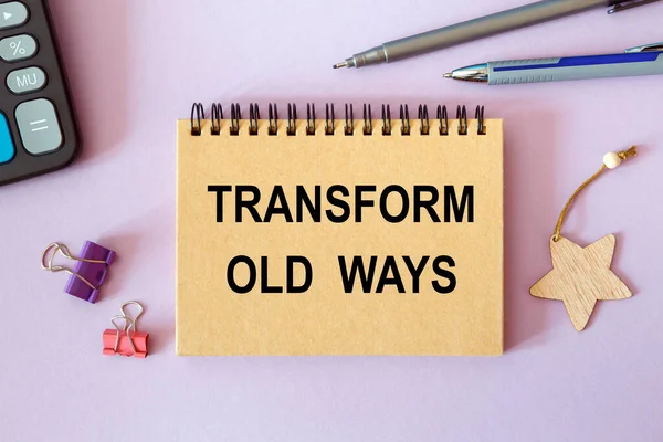 TRANSFORM OLD WAYS is written on a notepad, on an office desk with office accessories.