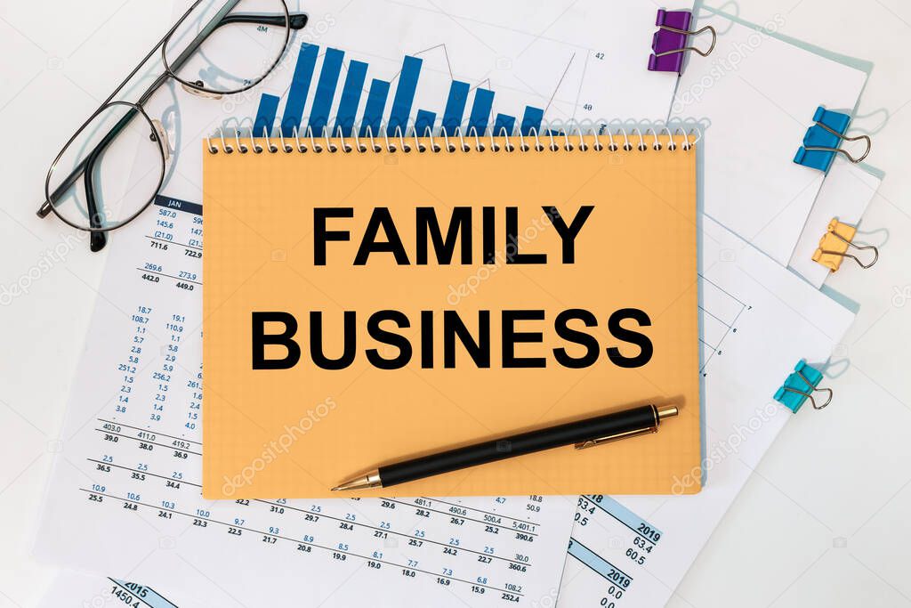 Notepad with the inscription Family business, documents, pen and glasses on a white background