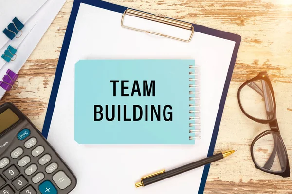 Team Building is written on a notepad on an office desk with office accessories.