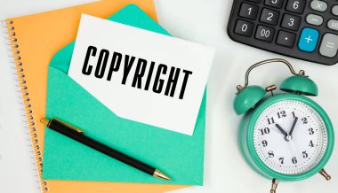 Bir posta zarfındaki kart. Metin fotokopi, saat, hesap makinesi, kalem..