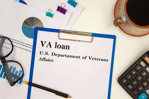 Paper with VA loan - U.S. Departament of Veterans Affairs on the table, calculator and glasses