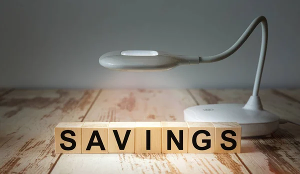 Een Tafellamp Verlicht Houten Blokken Met Het Woord Savings Bedrijfsconcept — Stockfoto