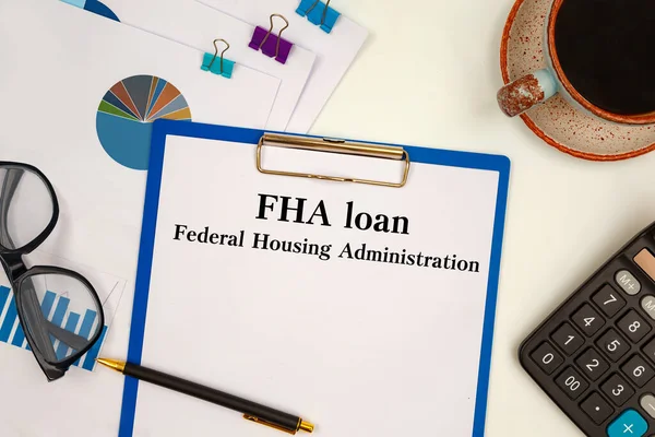 Paper with FHA loan - Federal Housing Administration on a table, calculator and glasses