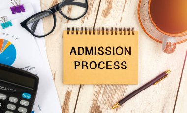 ADMISSION PROCESS bir ofis masasındaki bir not defterine yazılır..