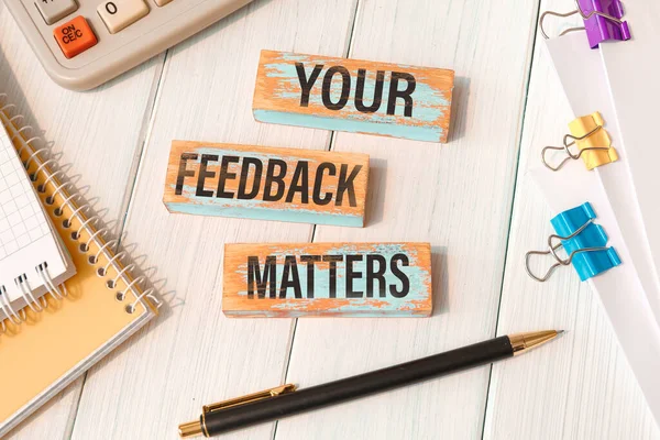 YOUR FEEDBACK MATTERS - words written on wooden blocks near office supplies