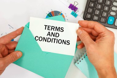 İş adamı zarftan bir kart çıkardı. Çalışma masasının arka planında yazılı şartlar ve koşullar vardı..