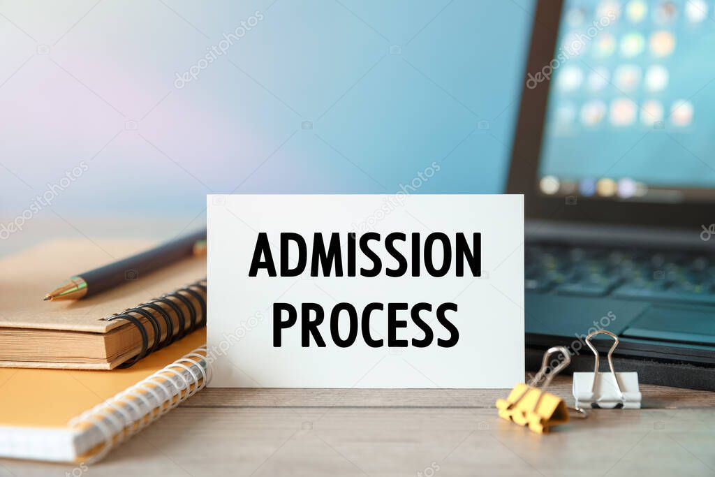 Admission Process - an inscription on a card near office supplies and computer