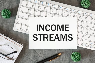 Gelir akışları ofis masasındaki bir belgede ofis aksesuarlarıyla birlikte yazılır..