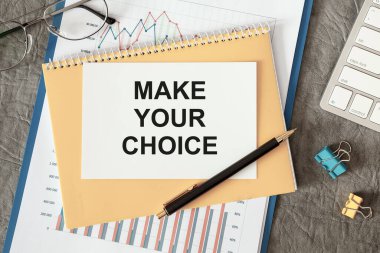 Seçimini yap. Ofis masasındaki bir belgede ofis aksesuarlarıyla birlikte yazılıdır..