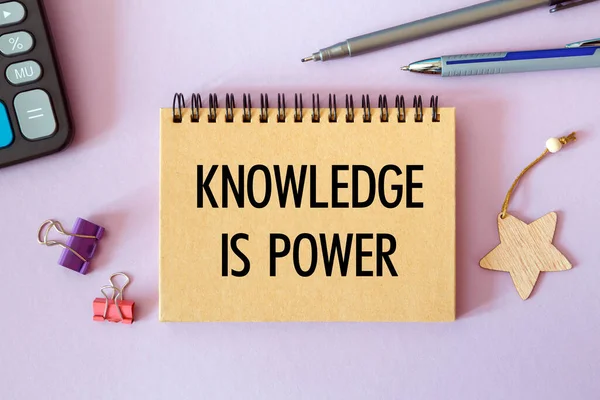 Knowledge is power - written on a notepad on an office desk with office accessories.