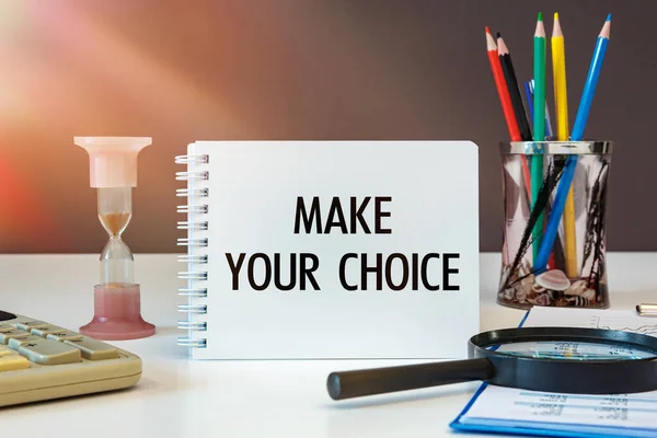 Make your choice is written on a notepad on an office desk with office accessories.