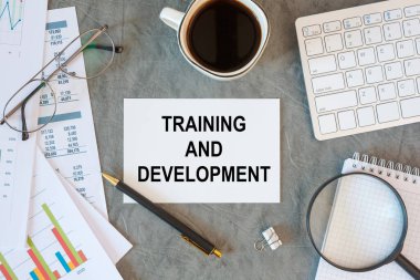 Eğitim ve Geliştirme büro masasındaki bir belgede ofis aksesuarlarıyla birlikte yazılır.