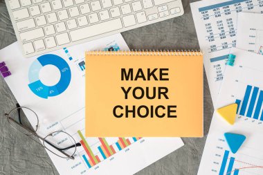 Seçimini yap. Ofis masasındaki bir belgede ofis aksesuarlarıyla birlikte yazılıdır..