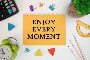 İş konsepti. Her anın tadını çıkar. Not defteri ve ofis malzemeleri hakkında ilham verici alıntılar.