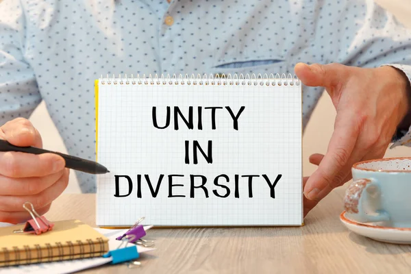 Notebook with the text - Unity in diversity - on the office table among the stationery.