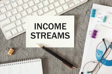 Gelir akışları ofis masasındaki bir belgede ofis aksesuarlarıyla birlikte yazılır..