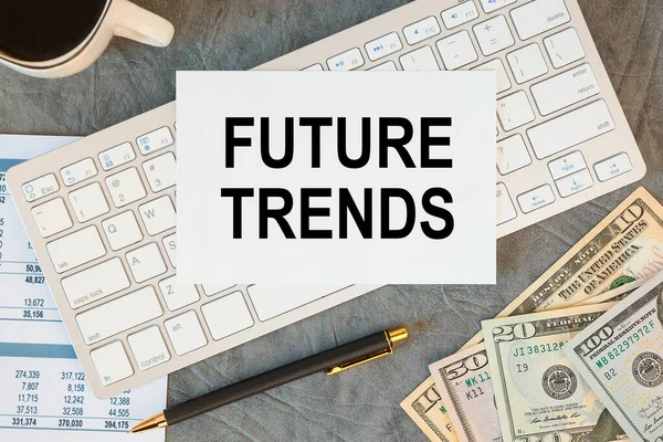 FUTURE TRENDS is written in a document on the office desk with office accessories, coffee, money and smartfon