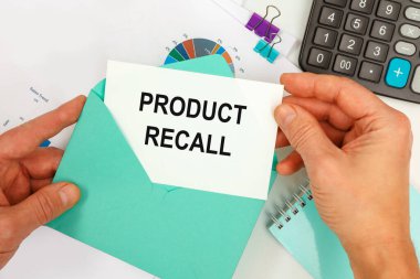 İş adamı zarftan bir kart çıkardı. Ofis masasının arka planında ProDUCT RECALL yazan bir kart..