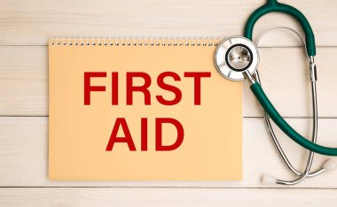 Üzerinde ilk yardım ve steteskop yazan bir not. Tıbbi konsept.