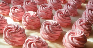 Parşömen arka planında el yapımı pembe şekerlemeler. Marshmallow, Meringue. Ev yapımı tatlı.