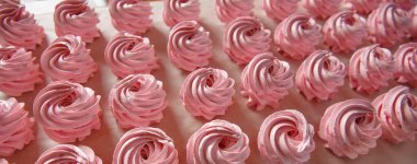 Parşömen arka planında el yapımı pembe şekerlemeler. Marshmallow, Meringue. Ev yapımı tatlı.