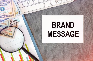 Brand MESAGE ofis masasındaki bir belgede ofis aksesuarları, klavye ve diyagramı ile birlikte yazılır