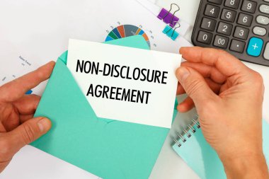 İş adamı zarftan bir kart çıkardı. Ofis masasının arkasında 