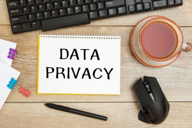 Ofis masası ve içinde DATA Özellikleri, klavye ve bir fincan çay olan defter.