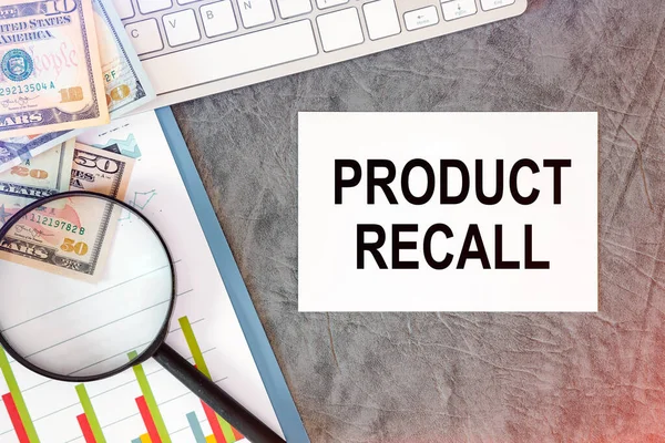 PRODUCT RECALL is written in a document on the office desk with office accessories, keyboard and diagram